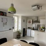 Cuisine commune avec table, évier et fenêtre donnant sur l’extérieur