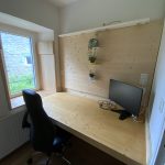 Bureau en alcôve boisée avec grand écran et chaise ergonomique