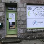Porte verte de La Hutte avec enseigne en bois au-dessus